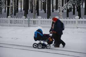 Family walking stroller in the snow